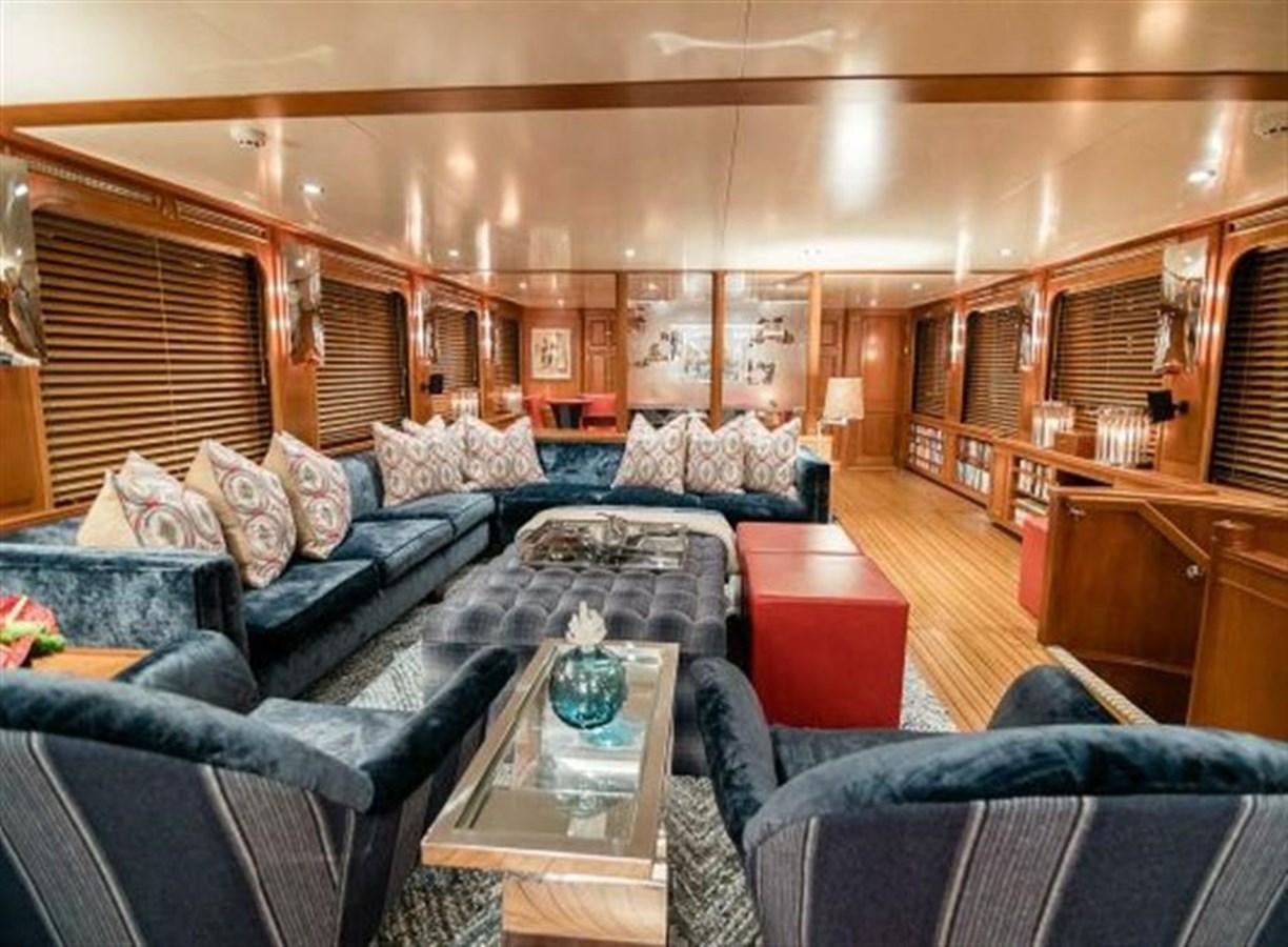 a living room with a blue couch aboard CHARISMA Yacht for Sale