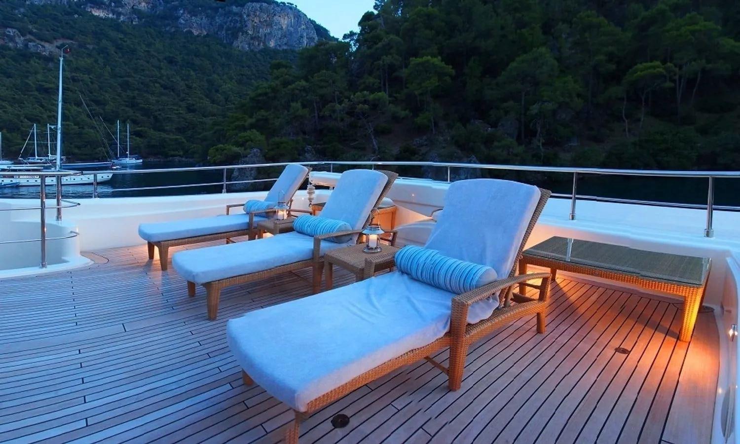 a deck with chairs and tables aboard ARIELA Yacht for Sale