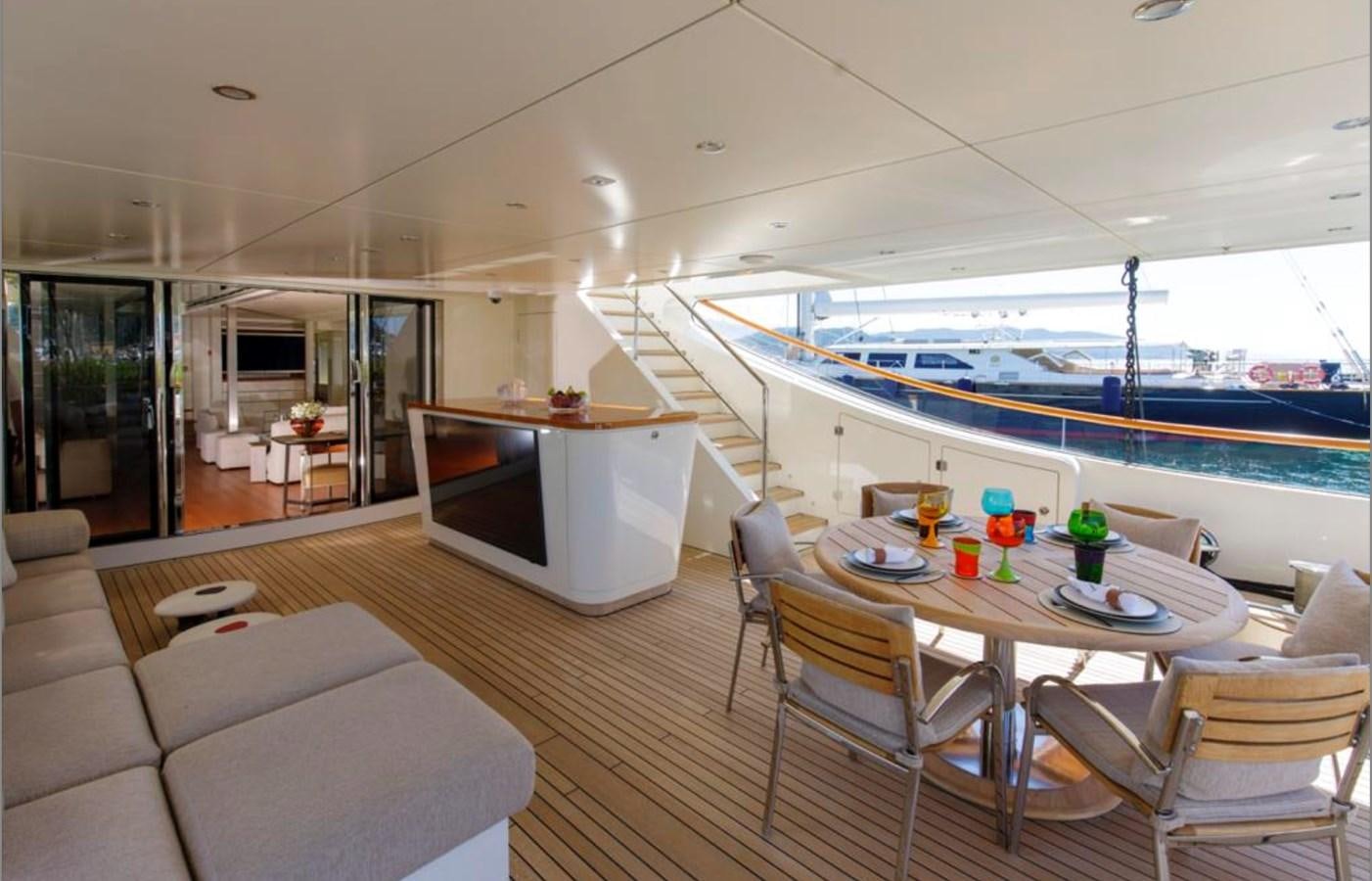 a large living room with a large boat in the background aboard BASMALINA II Yacht for Sale
