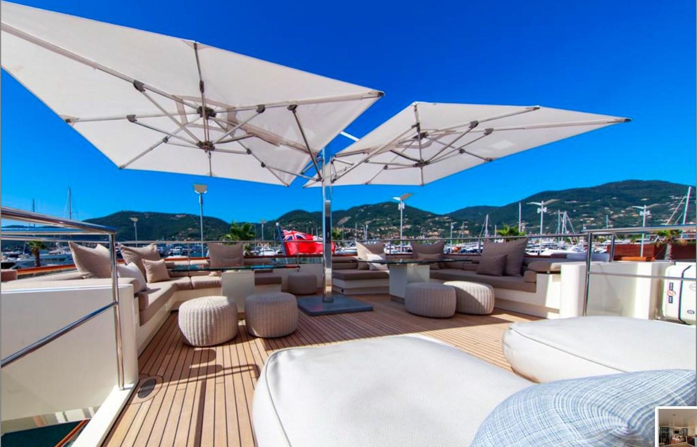 a large lounge area with a large umbrella over it aboard BASMALINA II Yacht for Sale