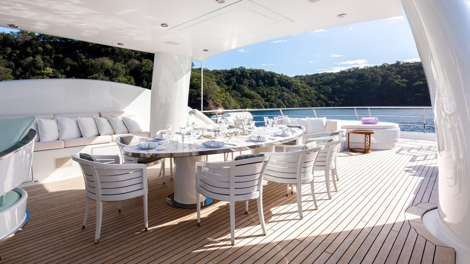 a table and chairs on a patio aboard STEP ONE Yacht for Sale