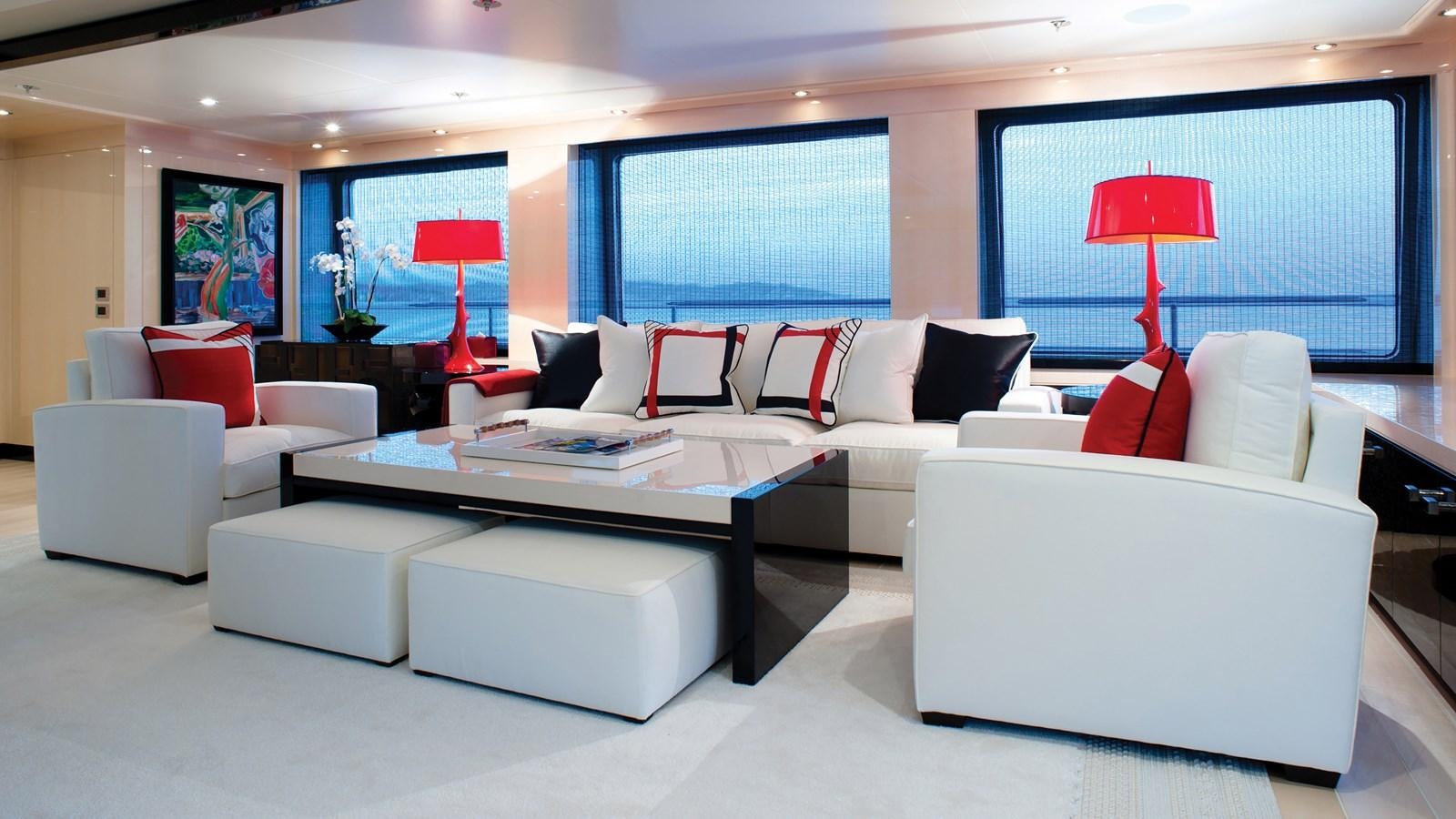 a living room with white couches and a red lamp aboard STEP ONE Yacht for Sale