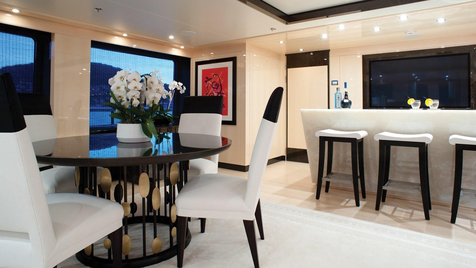 a room with tables and chairs aboard STEP ONE Yacht for Sale