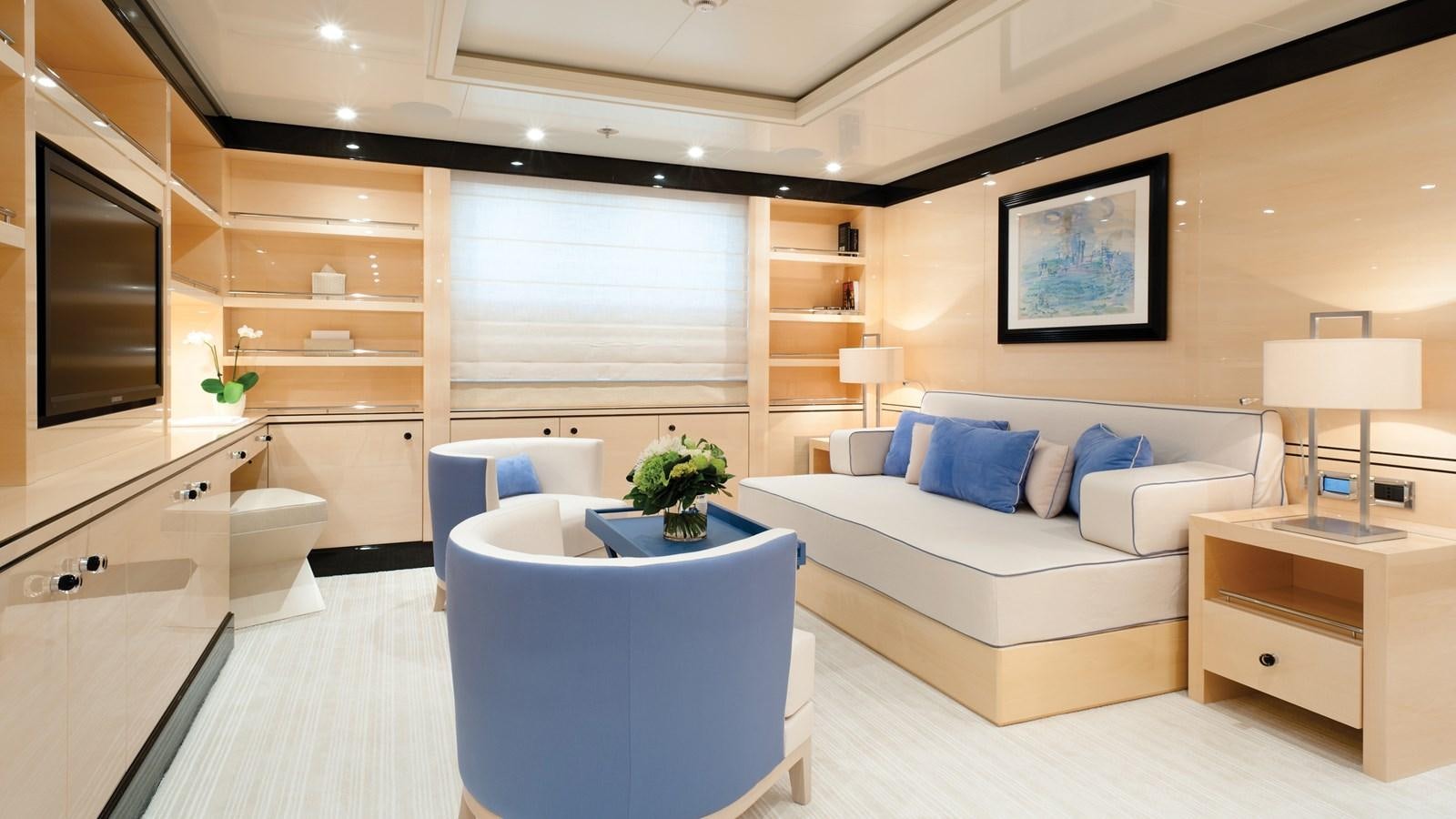 a modern living room with a white couch and a large television aboard STEP ONE Yacht for Sale