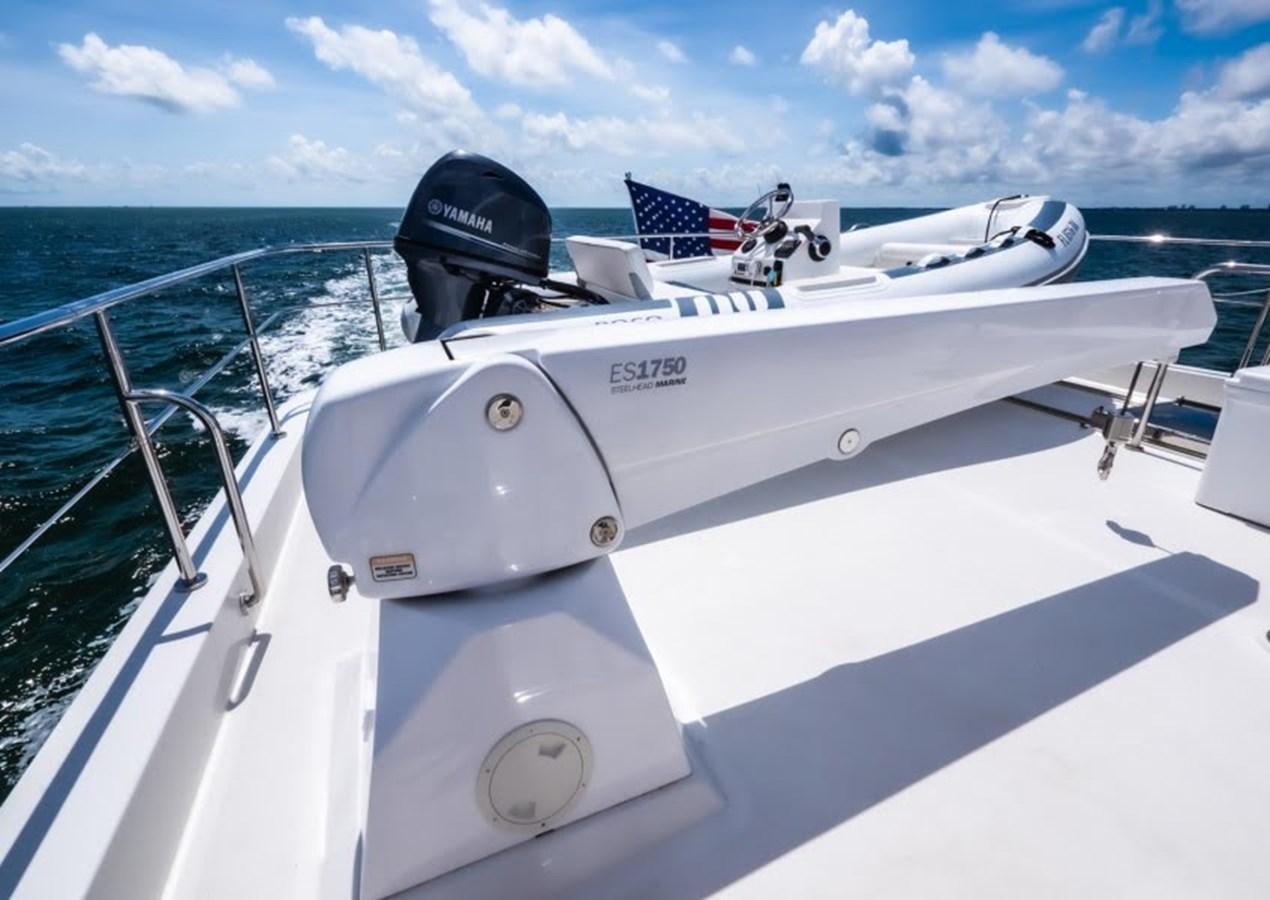a white boat with a blue and white flag on it aboard PHOENIX Yacht for Sale
