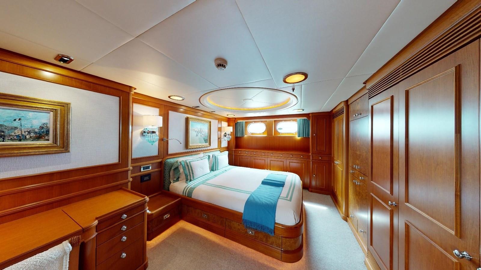 a room with a bed and a wood cabinet aboard ADYTUM Yacht for Sale