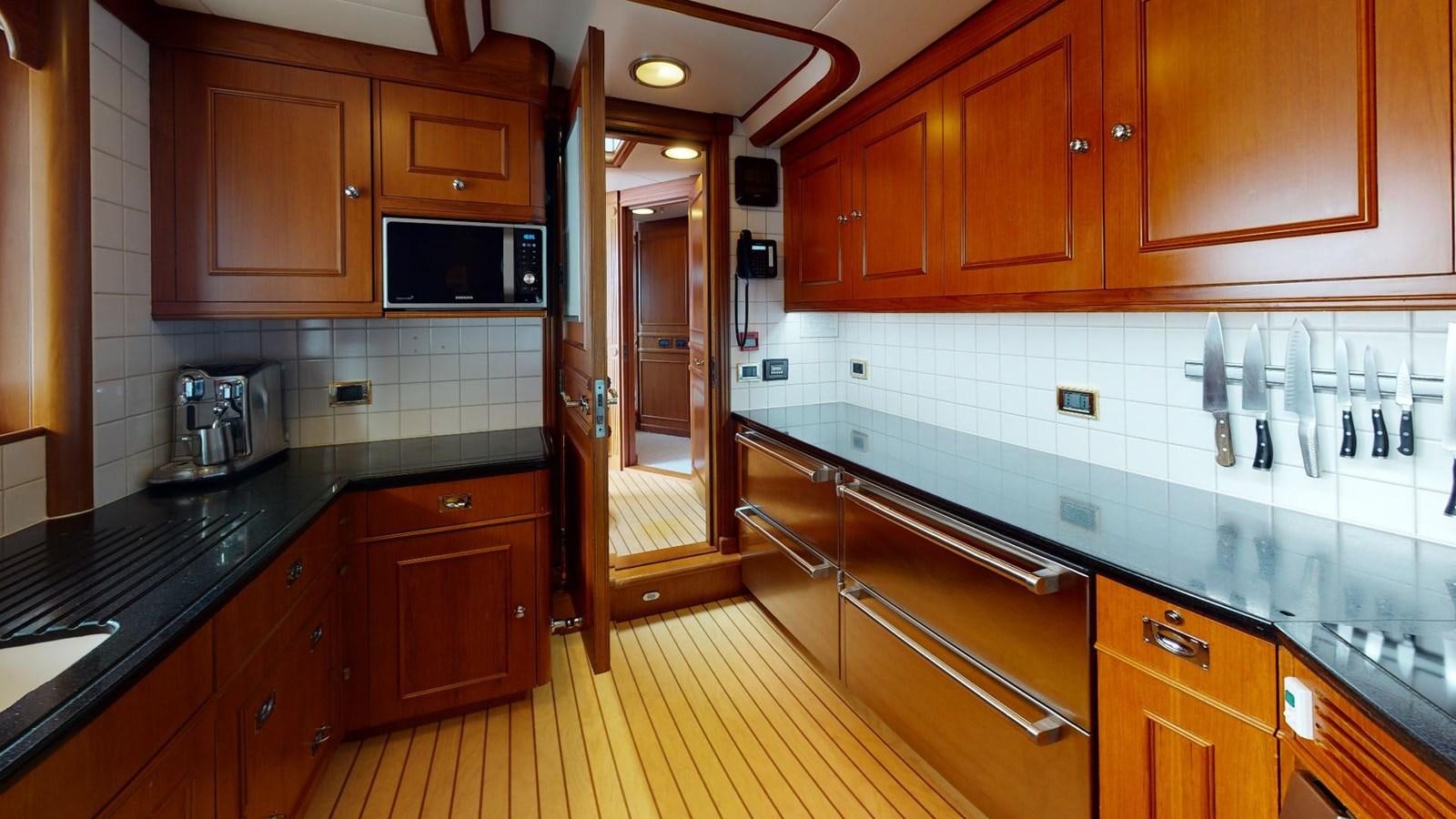 a kitchen with wooden cabinets aboard ADYTUM Yacht for Sale