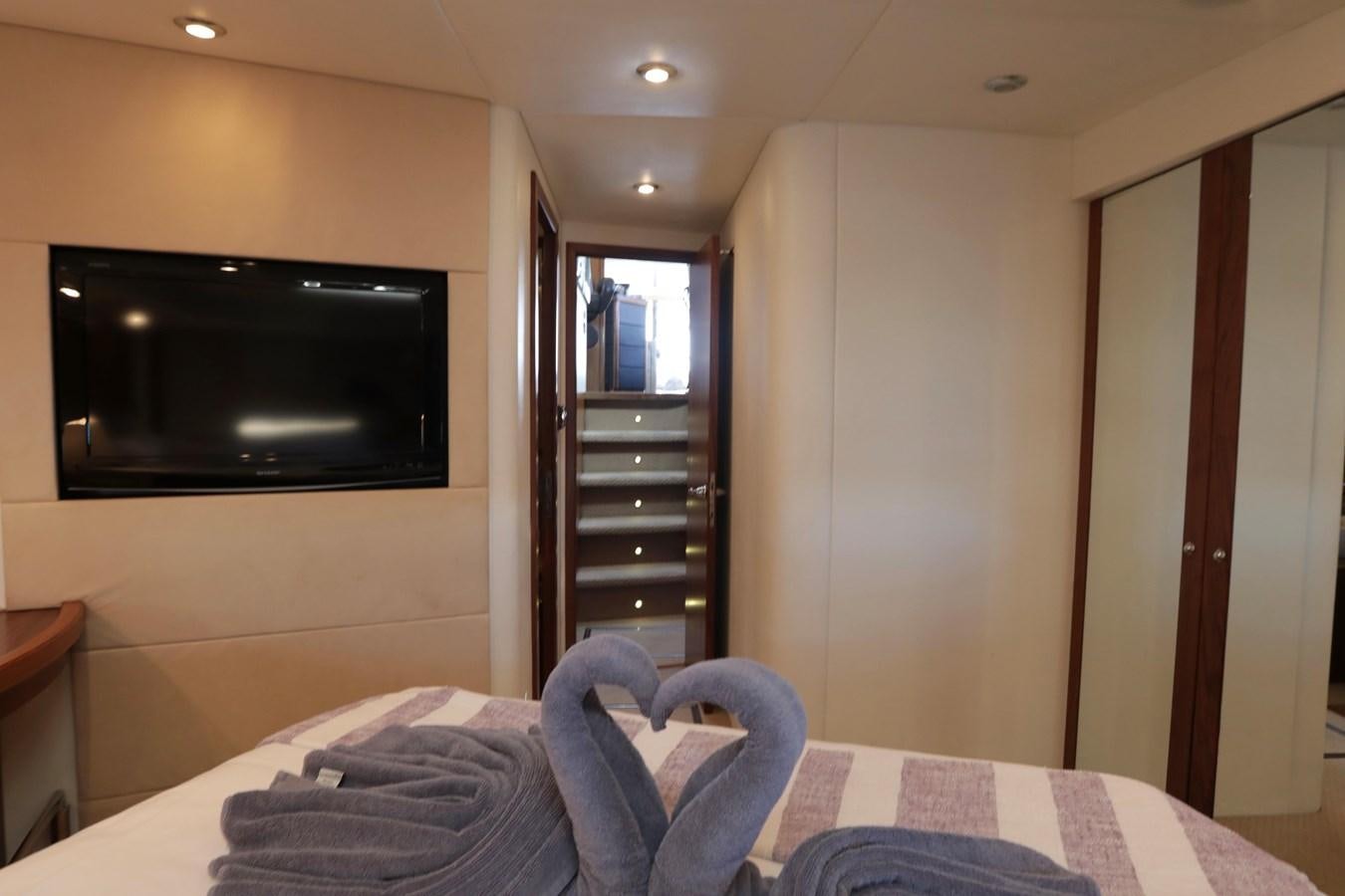 a bed and tv in a room aboard CAPRICHO II Yacht for Sale