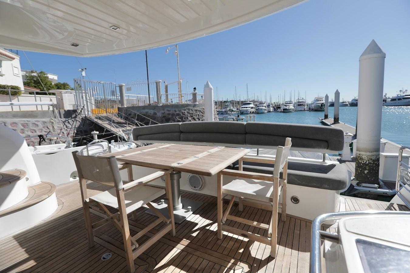 a table and chairs on a deck aboard CAPRICHO II Yacht for Sale