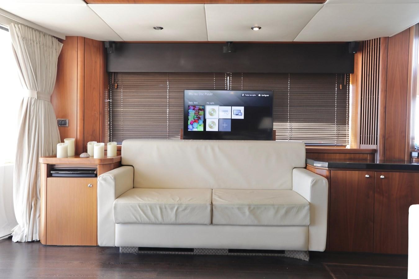 a living room with a couch and tv aboard CAPRICHO II Yacht for Sale