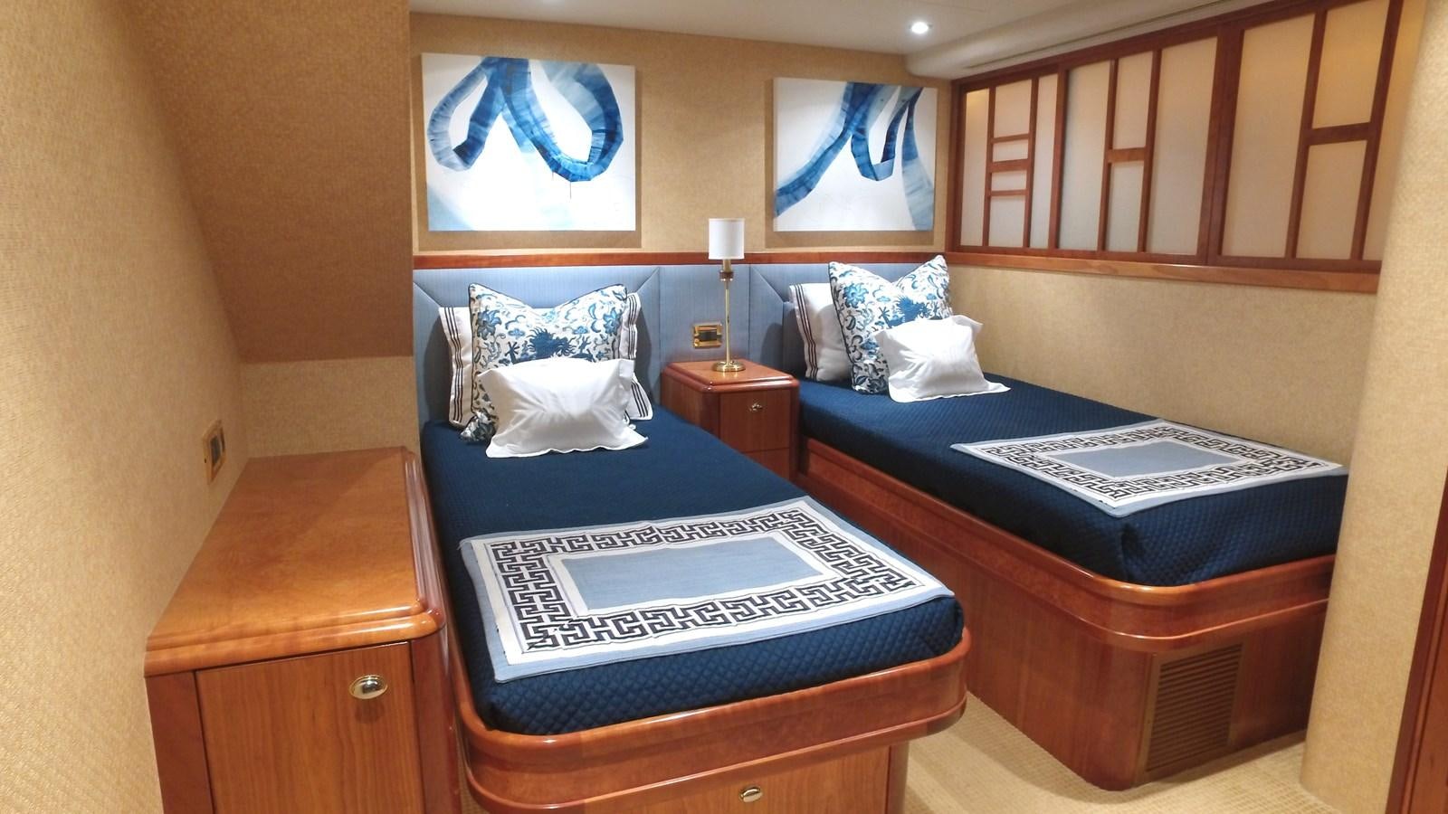 a bed with a blue bedspread and a wooden cabinet aboard SHORT GAME Yacht for Sale