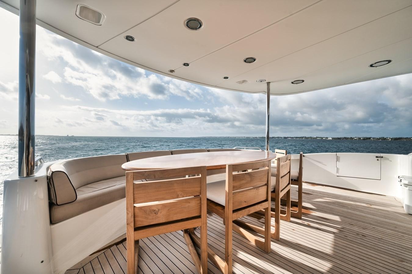a deck with chairs and a table on it aboard BELLA CONTESSA Yacht for Sale