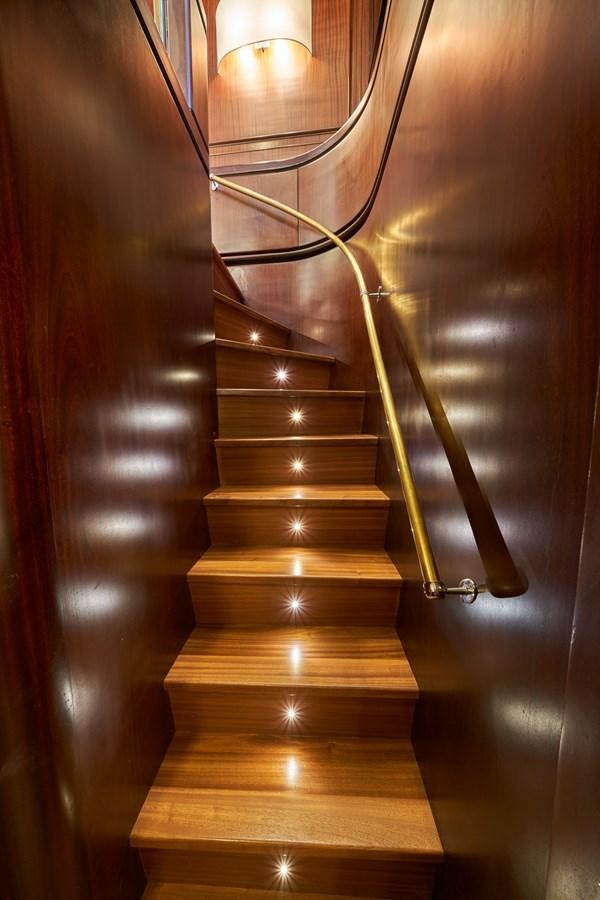a wooden staircase with a light fixture aboard EL CARAN Yacht for Sale