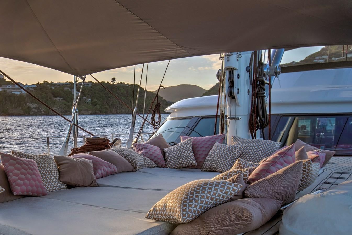 a bed with pillows and a sailboat in the background aboard MARE NOSTRUM Yacht for Sale