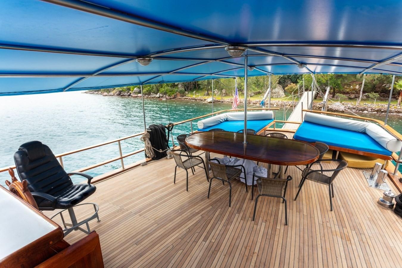 a table and chairs on a deck overlooking a body of water aboard ROYAL MARIS Yacht for Sale