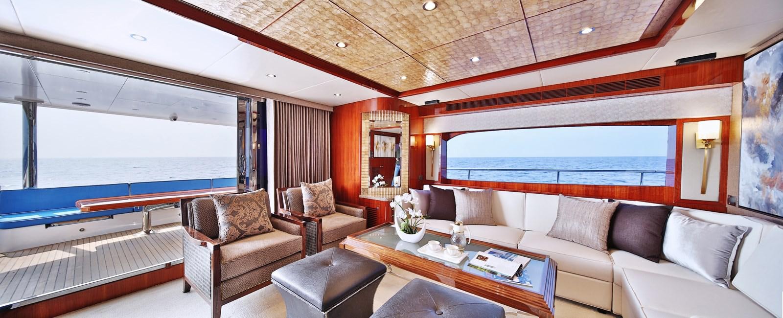 a room with a couch and a table and a large window aboard JOHNSON 80' SKYLOUNGE W/HYDRAULIC PLATFORM Yacht for Sale