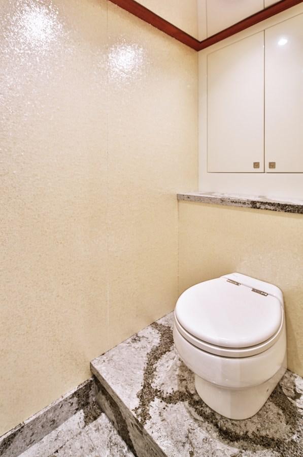 a toilet in a bathroom aboard JOHNSON 80' SKYLOUNGE W/HYDRAULIC PLATFORM Yacht for Sale
