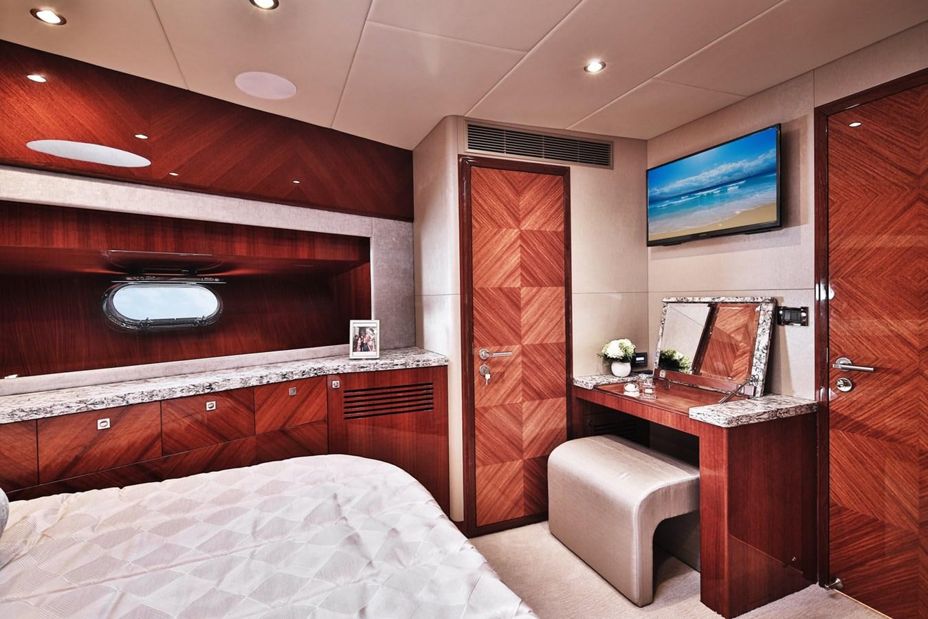 a bedroom with a bed and a television aboard JOHNSON 80' SKYLOUNGE W/HYDRAULIC PLATFORM Yacht for Sale