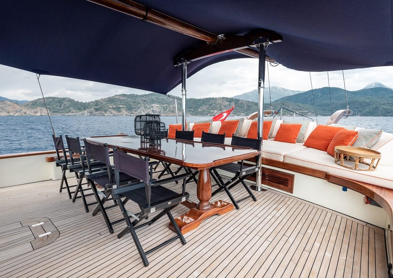 a table and chairs on a deck aboard CAPTAIN COOK Yacht for Sale