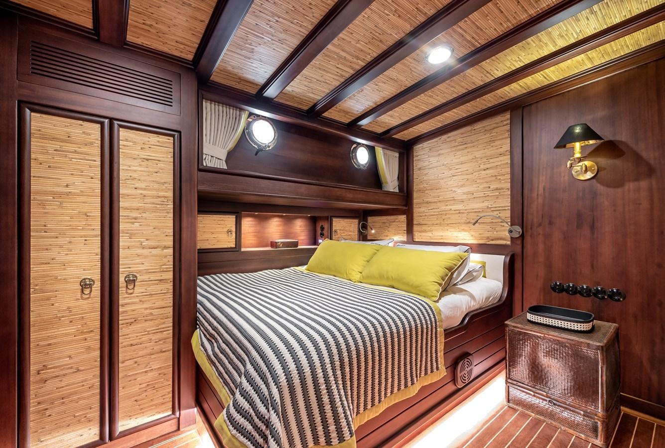 a bedroom with a bed and a wood door aboard CAPTAIN COOK Yacht for Sale