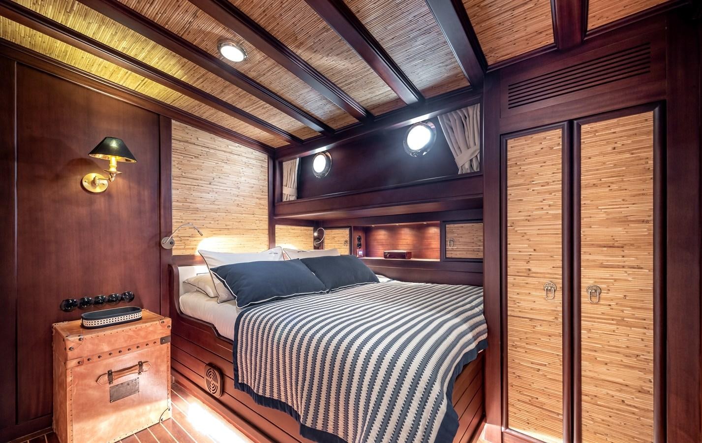 a room with a bed and a wood door aboard CAPTAIN COOK Yacht for Sale