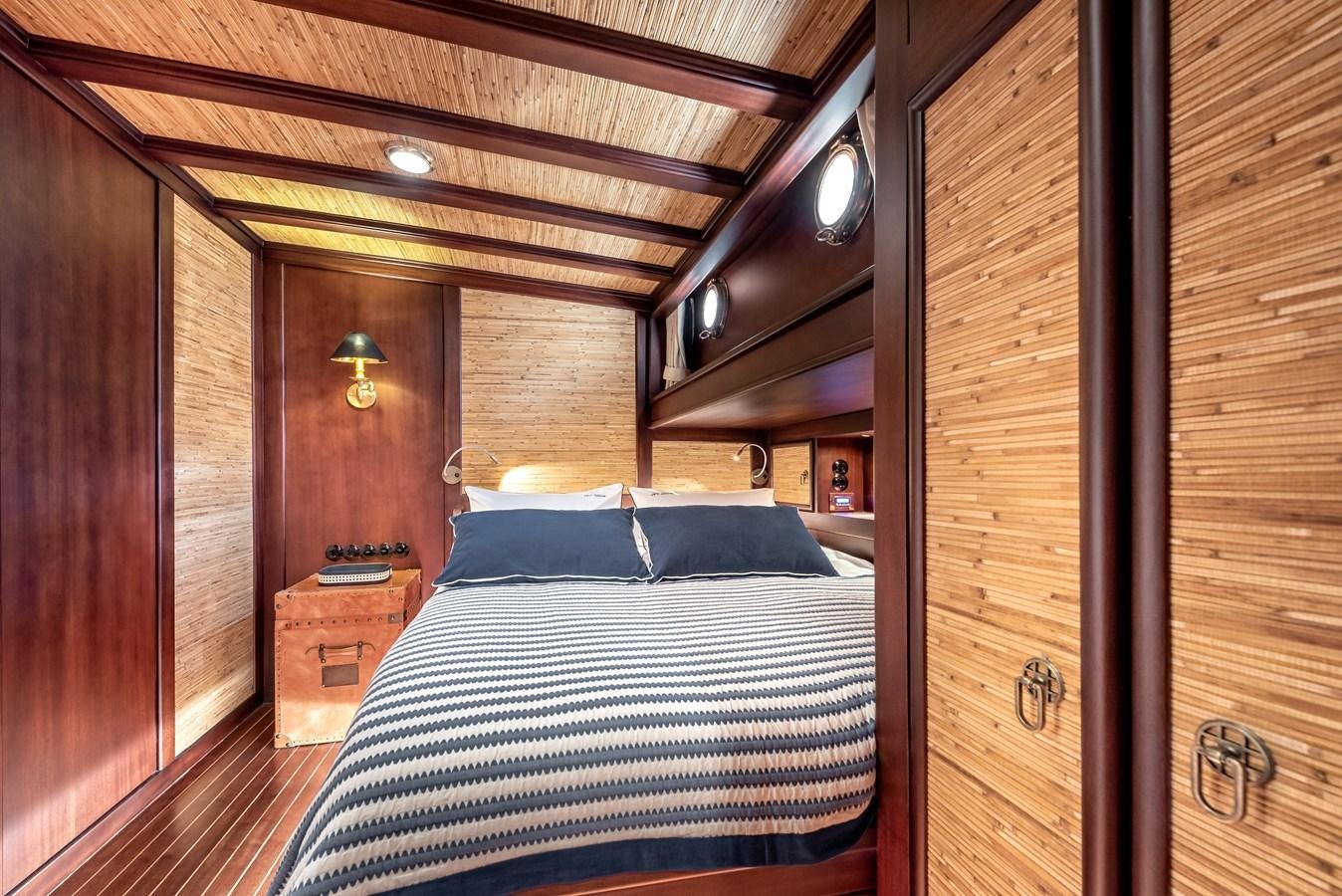 a wood paneled room with a bed and a lamp aboard CAPTAIN COOK Yacht for Sale