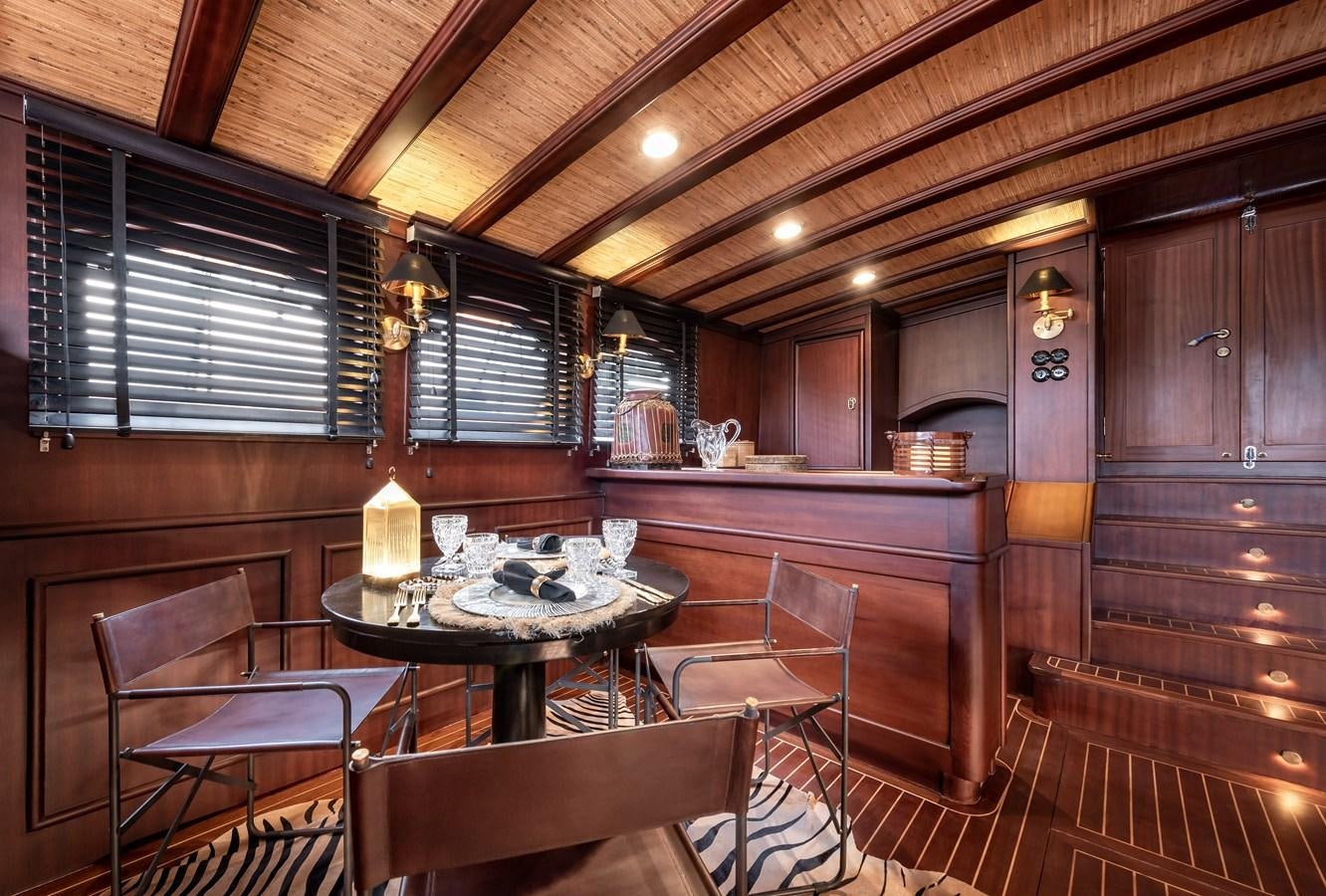 a wooden cabin with a table and chairs aboard CAPTAIN COOK Yacht for Sale