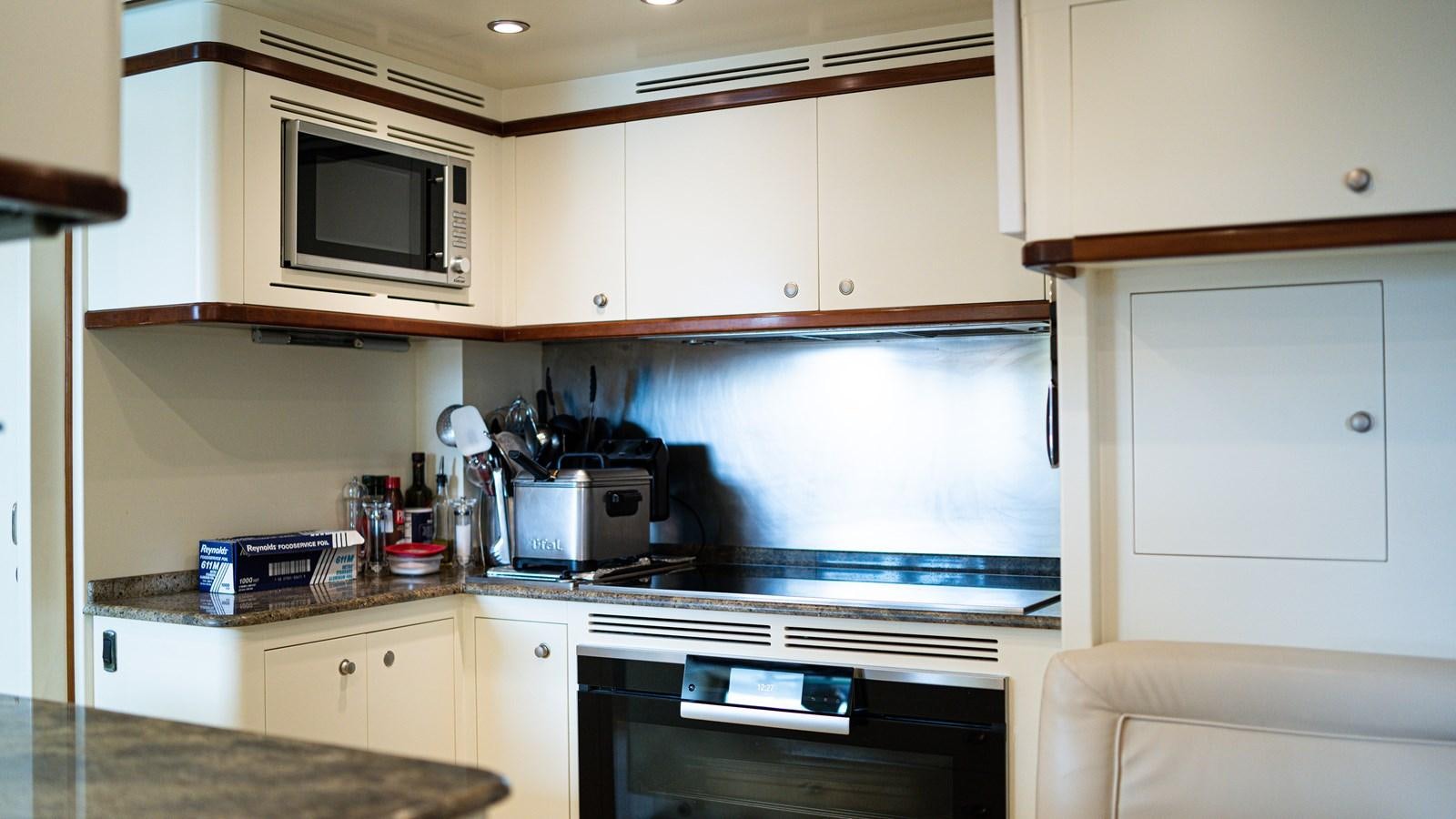 a kitchen with white cabinets aboard ORINOKIA Yacht for Sale