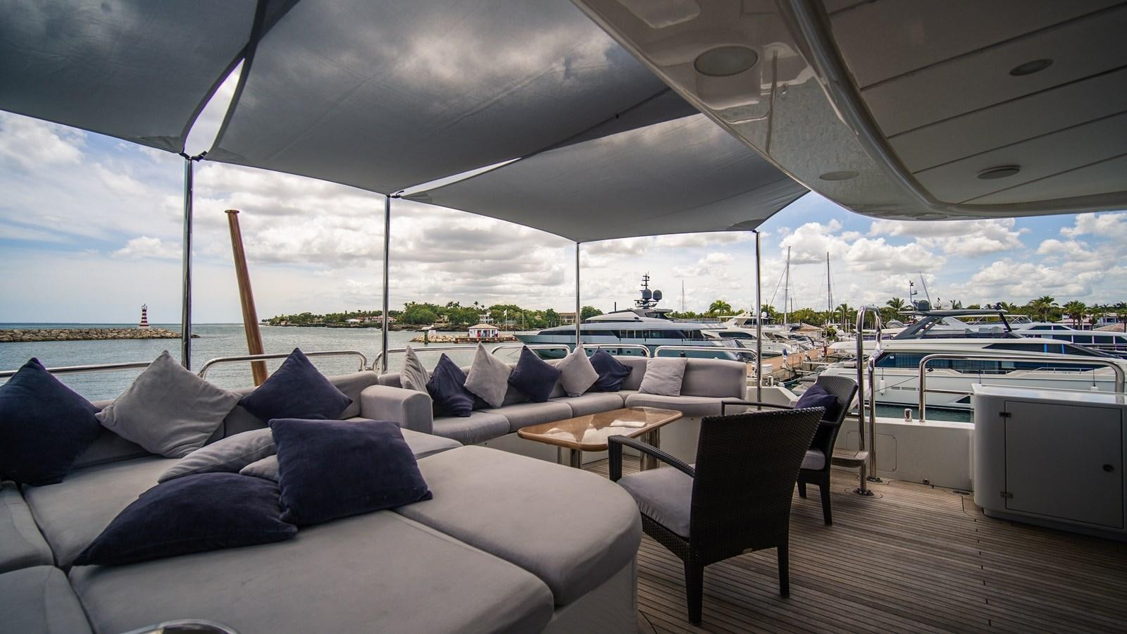 a large lounge area with a large deck and a large boat in the background aboard ORINOKIA Yacht for Sale