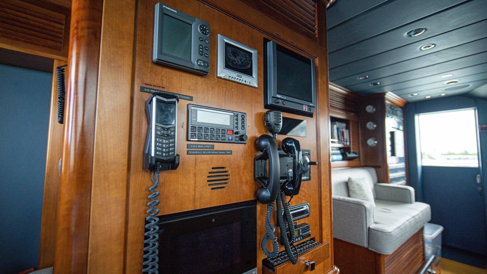 a radio and a guitar on a wood table in a living room aboard ORINOKIA Yacht for Sale