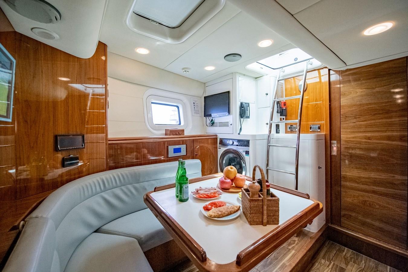 a kitchen with a table and a couch aboard SERAFIM Yacht for Sale