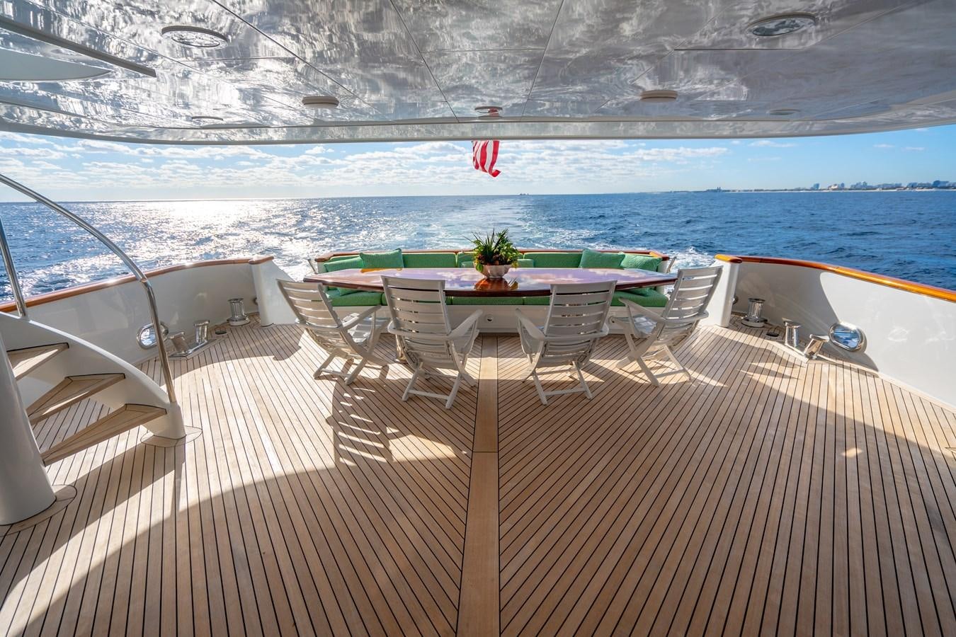 a deck with a table and chairs on it aboard SEA DREAMS Yacht for Sale