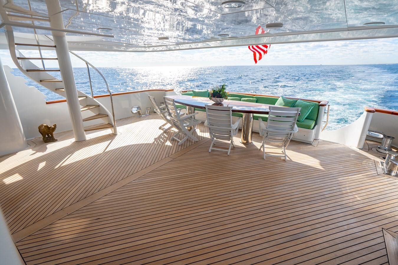 a deck with a table and chairs on it aboard SEA DREAMS Yacht for Sale