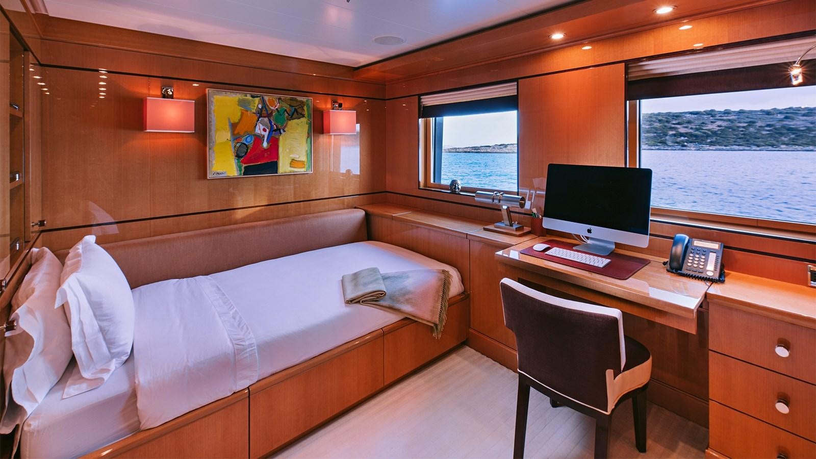 a room with a bed and a desk aboard ARIELA Yacht for Sale