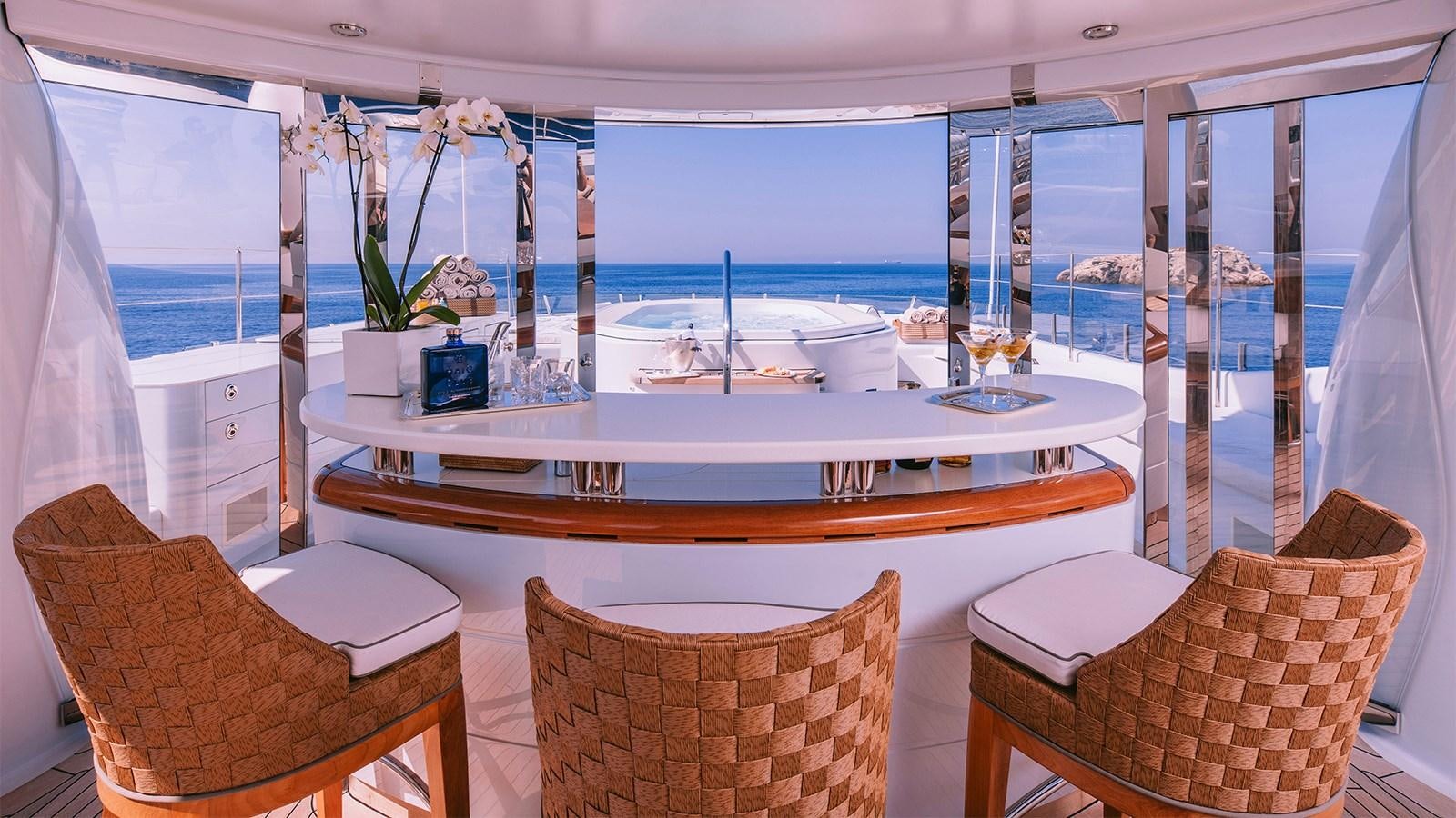 a room with a table chairs and a view of the ocean aboard ARIELA Yacht for Sale