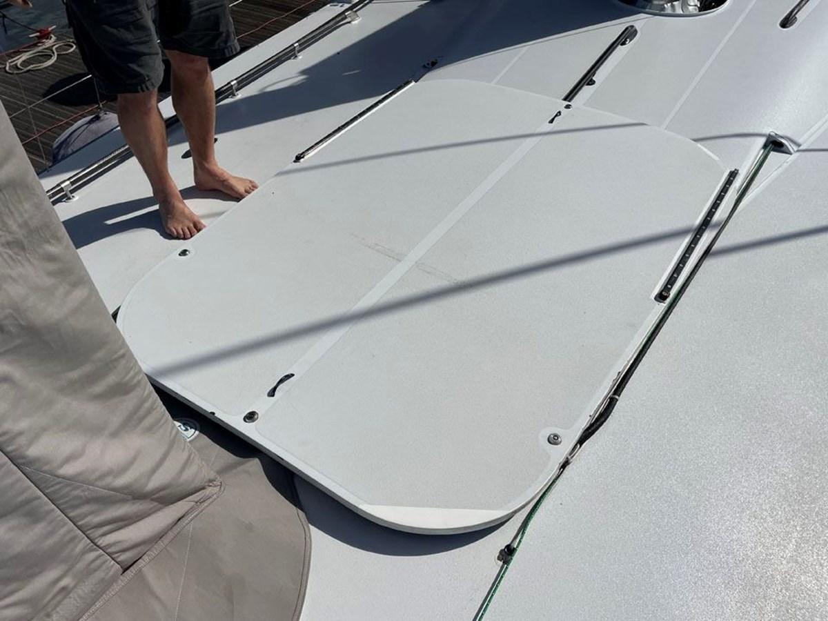 a person standing next to a white surfboard aboard BLACK JACK IV Yacht for Sale