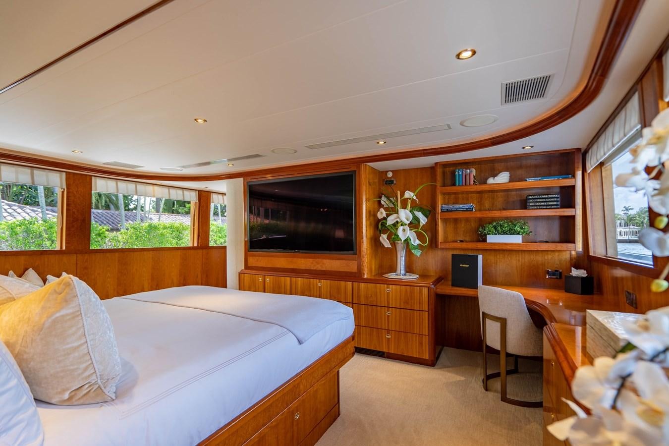 a bedroom with a bed and a desk aboard YOLO Yacht for Sale