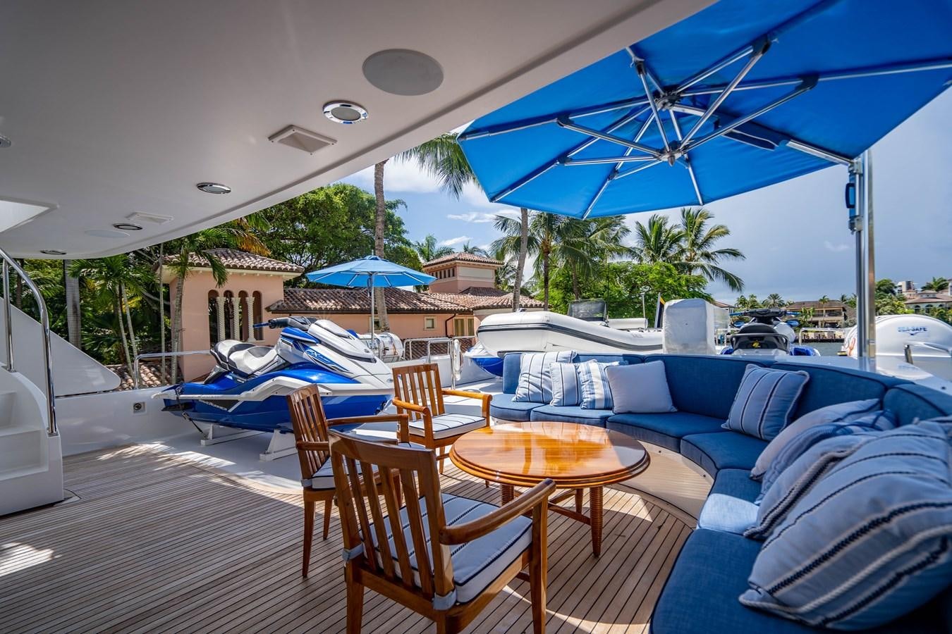 a deck with chairs and tables aboard YOLO Yacht for Sale