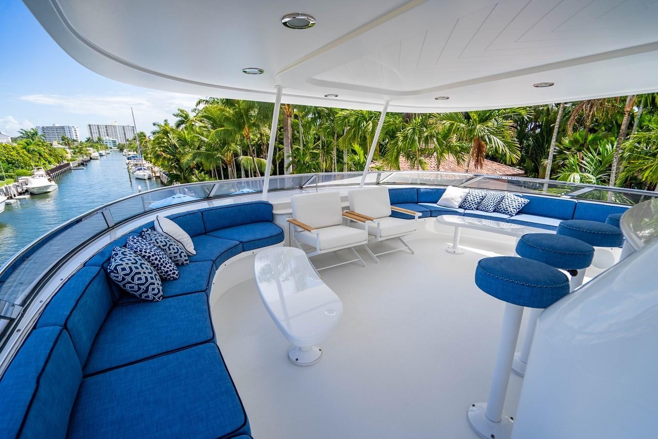 a pool with lounge chairs and a pool with trees and buildings in the background aboard YOLO Yacht for Sale