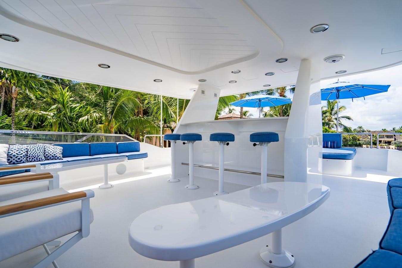 a pool with tables and chairs aboard YOLO Yacht for Sale
