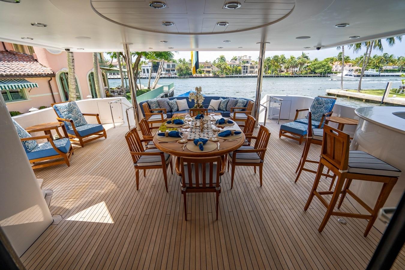 a room with a table chairs and a pool aboard YOLO Yacht for Sale