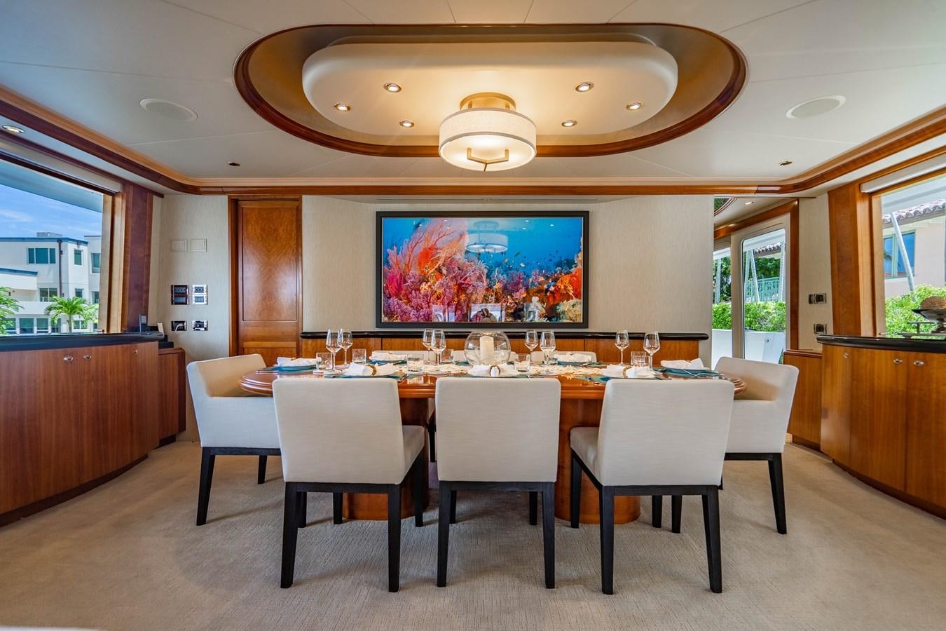 a large room with a table and chairs aboard YOLO Yacht for Sale