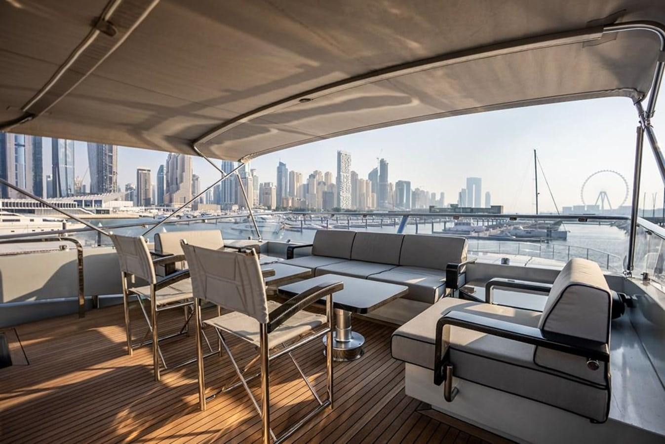 a boat deck with chairs and a city skyline in the background aboard LADY MAIA Yacht for Sale