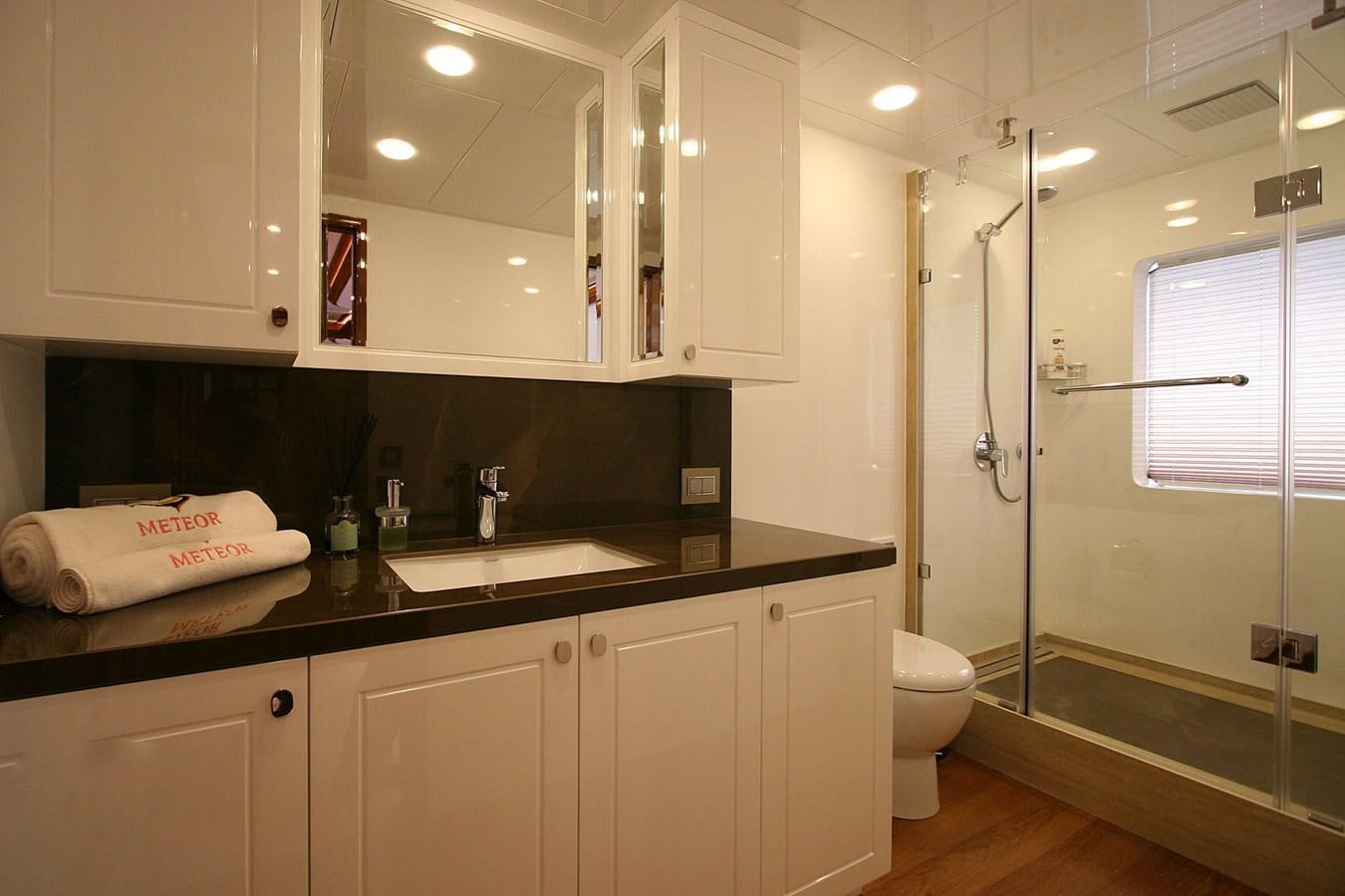 a bathroom with a glass shower aboard METEOR Yacht for Sale