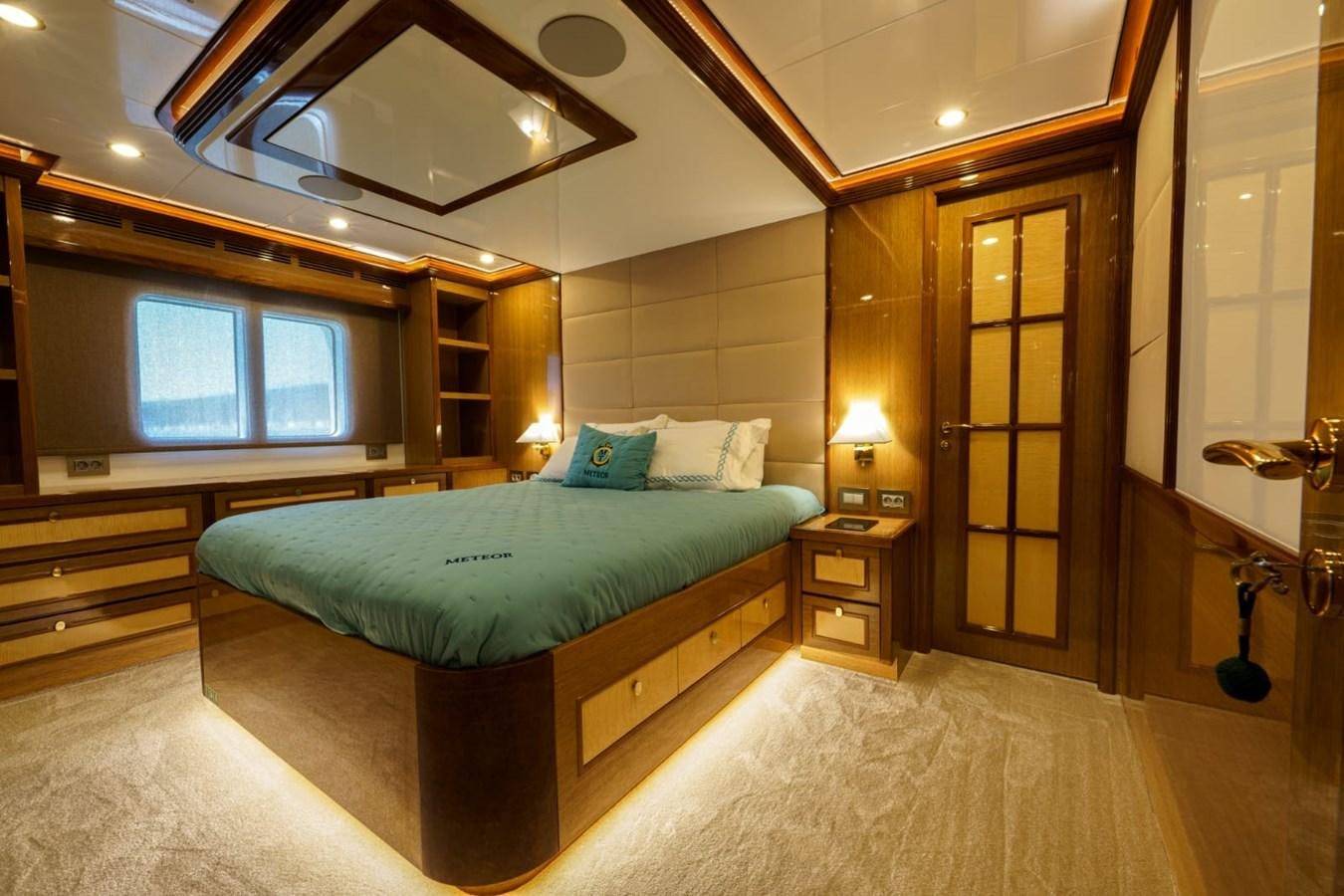 a large bedroom with a large mirror aboard METEOR Yacht for Sale