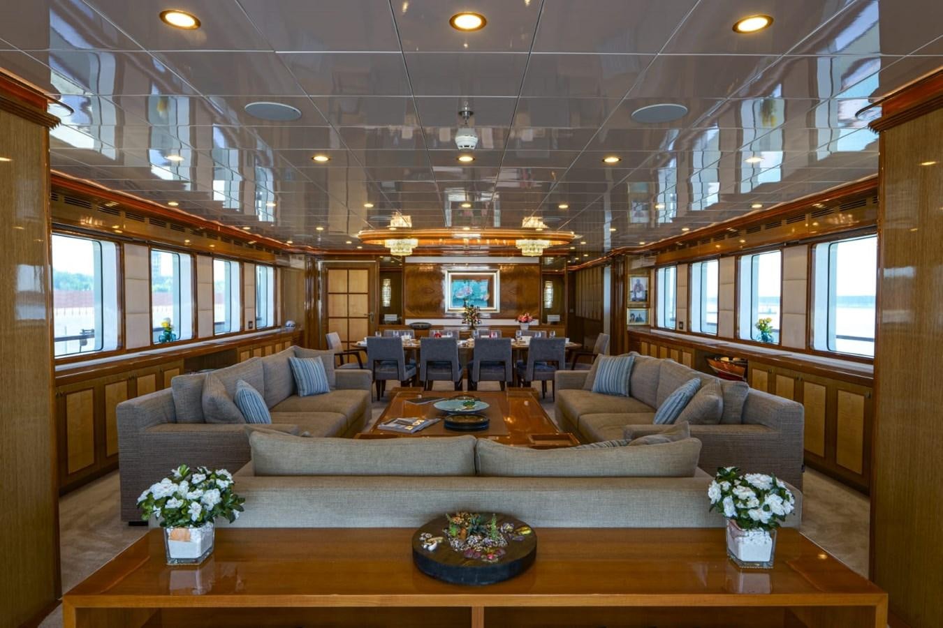 a living room with a large wood table and a large window aboard METEOR Yacht for Sale