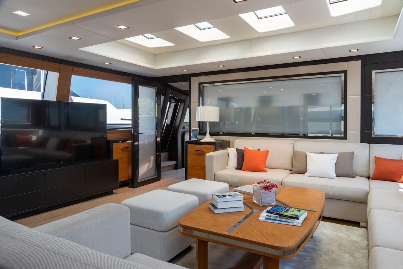 a living room with a large television and a table aboard ASYA Yacht for Sale