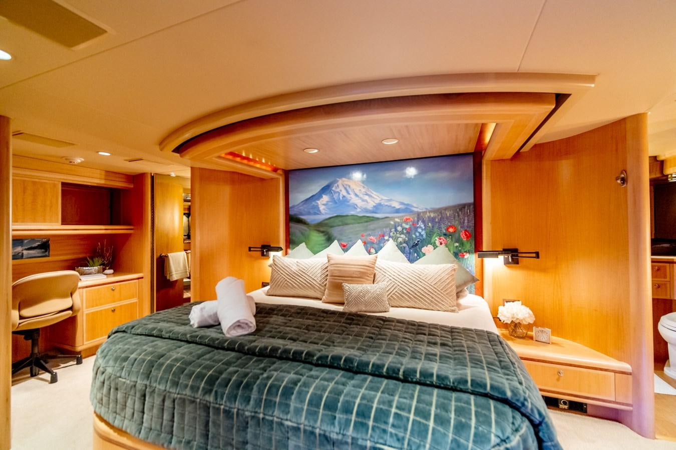 a bedroom with a bed and a painting on the wall aboard SHADOWFAX Yacht for Sale