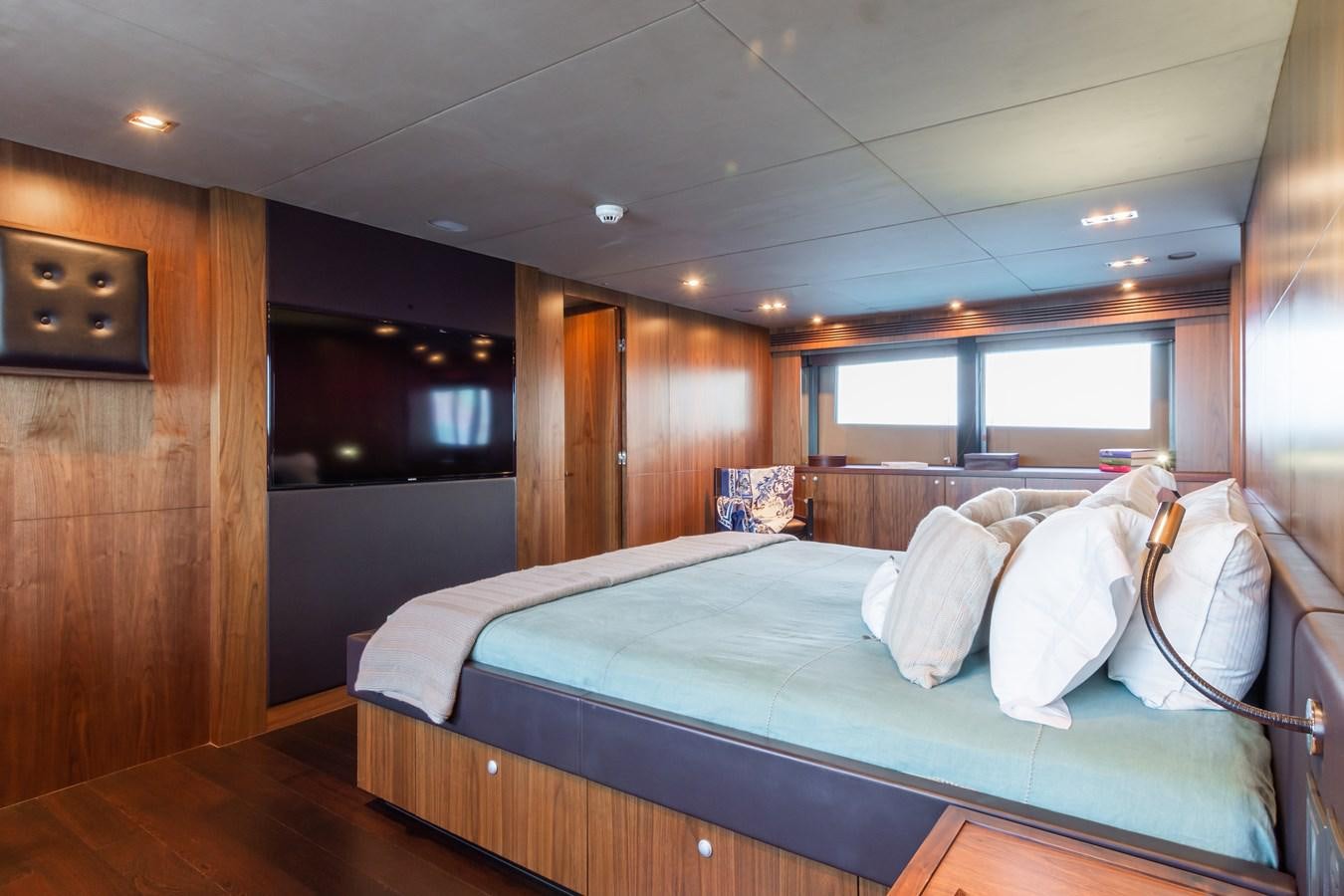 a bedroom with a bed and a wood wall aboard DESEO Yacht for Sale