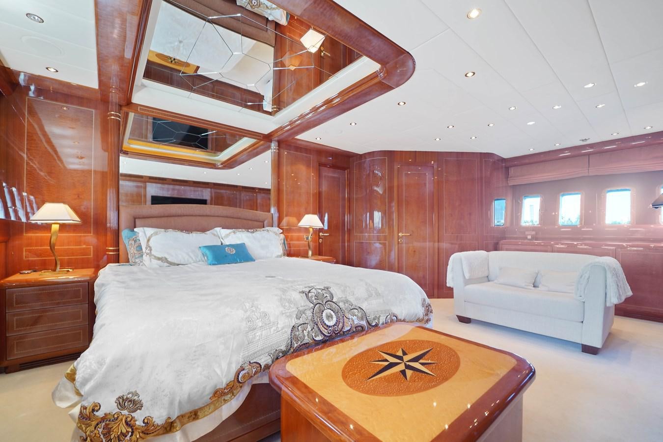 a bedroom with a bed and a table aboard 108' MANGUSTA 2002 Yacht for Sale